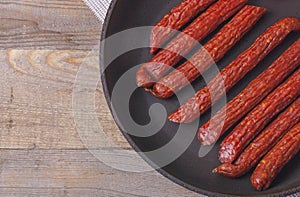 Sausages on a wooden kitchen board close up, cooking meat snacks