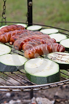 Sausages and zucchini  being barbequed