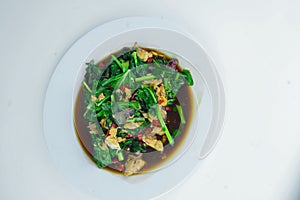 Sauted Romaine lettuce with scrambled eggs and chopped chilis, served on a white plate