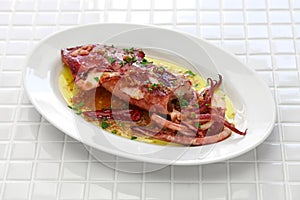 Sauteed calamari with parsley and garlic, spanish tapas food photo