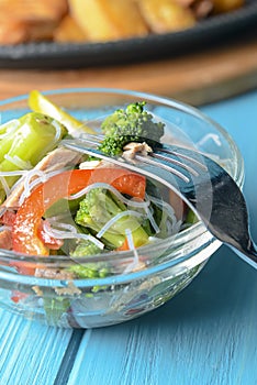 Sauteed vegetable salad with broccoli, asparagus, sweet pepper and cellophane noodles or fensi noodles in a glass bowl