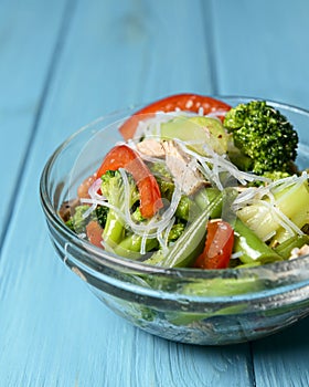 Sauteed vegetable salad with broccoli, asparagus, sweet pepper and cellophane noodles or fensi noodles in a glass bowl