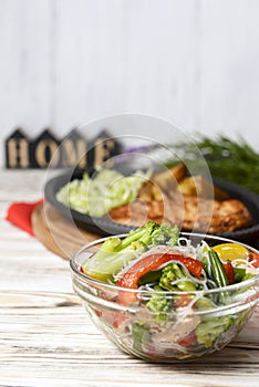 Sauteed vegetable salad with broccoli, asparagus, sweet pepper and cellophane noodles or fensi noodles in a glass bowl