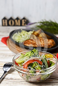 Sauteed vegetable salad with broccoli, asparagus, sweet pepper and cellophane noodles or fensi noodles in a glass bowl