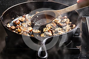 Sauteing sliced mushrooms in a skillet