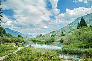 Sava Dolinka river and some tourists at the Zelenci Nature Reserve in Kranjska Gora, Slovenia