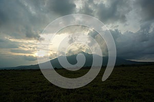 Savanna in the rainy season with green grass against a mountain backdrop