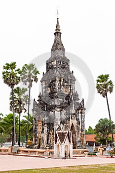 Savannakhet Laos-December 28 2018 :  Travel attraction at That Ing Hang, Ancient herritage of old pagoda with palm trees on white