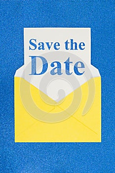 Save the Date message on white card with a yellow envelope photo