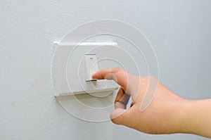 Save electricity Close up of finger is turning on or off on light switch. woman hand with finger on light switch Copy space.