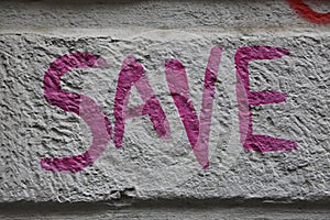 Save inscription on the stone concrete wall. SAVE/ graffiti