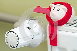 Save money heating concept with thermostat and piggy bank