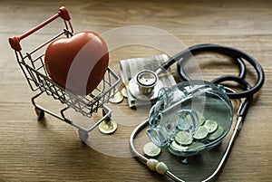 Save money for Medical insurance and Health care concept. Hospital budget and clinic fees. Piggy bank and stethoscope on wooden