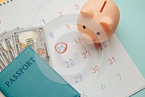 Save money for travelling. Piggy bank and passport with money on calendar