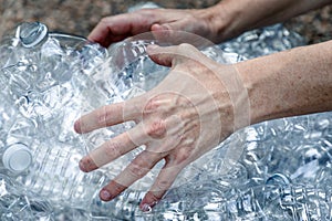 Save our environment. Female hands grabbing plastic bottles