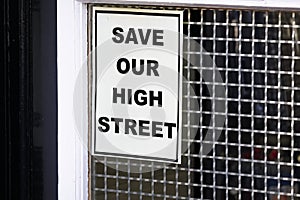 Save our high street sign on closed shop window due to online shopping and recession in the uk