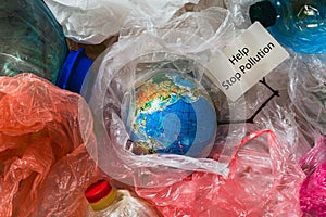 Save our planet or World Environment Day concept Earth in plastic bags holds card with inscription help