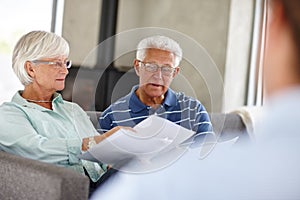 Save a penny, earn a penny. Over-the-shoulder shot of a financial advisor meeting with a senior couple at their home.