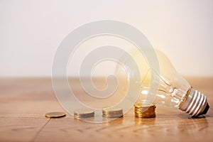 Save power to save the earth concept with coins stack, light bulb with new knowledge on wooden backgrounds and new idea concept.