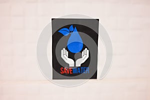 Save water sign on the wall in the hotel. Concept of ecology, environmental protection. Earth Day