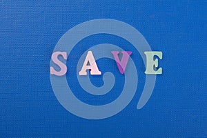 SAVE word on blue background composed from colorful abc alphabet block wooden letters, copy space for ad text. Learning english