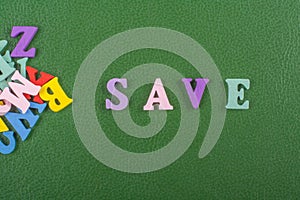 SAVE word on green background composed from colorful abc alphabet block wooden letters, copy space for ad text. Learning english c