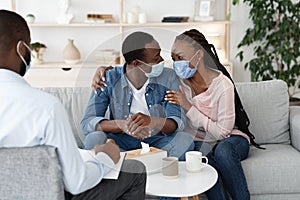 Saved Marriage. Happy Black Couple In Medical Masks Embracing At Councelor`s Office