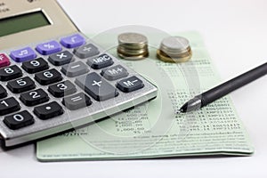 Saving account book. Includes a calculator, pen, and a blank coin on the account book