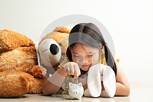 Saving and business concept, Cute girl with piggy bank and coins at home