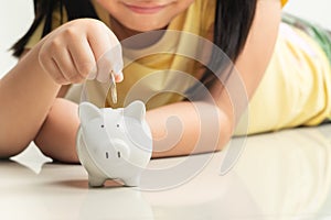 Saving and business concept, Cute girl with piggy bank and coins at home