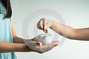 Saving and business concept, two little girl with piggy bank and coins at home