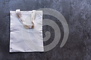 Saving Earth. White tote bag canvas package and fabric cloth eco shopping on blackboard background.