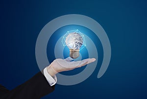 Saving energy, and earth day concept. Businessman holding glowing earth light bulb. Element of this image are furnished by NASA