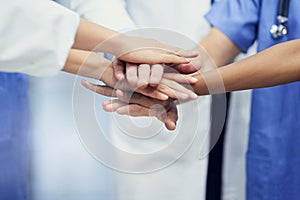 Saving lives together. Closeup shot of a group of medical professionals standing in a huddle with their hands together.