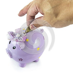 Saving, male hand putting a money into piggy bank isolated on white background