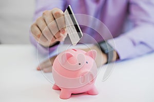 Saving money, businessman holding piggy bank and credit card