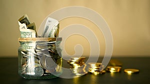 Saving money coin in jar. Symbol of investing, keeping money concept. Collecting cash banknotes in glass tin as moneybox