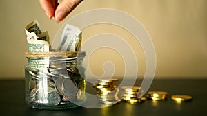 Saving money coin in jar. Symbol of investing, keeping money concept. Collecting cash banknotes in glass tin as moneybox