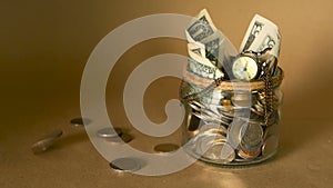 Saving money coin in jar. Symbol of investing, keeping money concept. Collecting cash banknotes in glass tin as moneybox