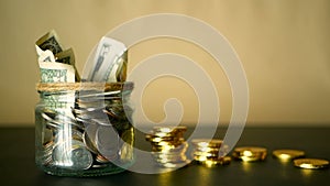 Saving money coin in jar. Symbol of investing, keeping money concept. Collecting cash banknotes in glass tin as moneybox