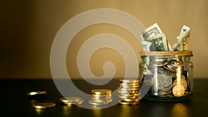 Saving money coin in jar. Symbol of investing, keeping money concept. Collecting cash banknotes in glass tin as moneybox