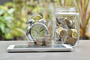 Saving money concept with money coin stack on smart-phone