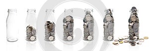 Saving money concept of collecting coins in glass bottle from e