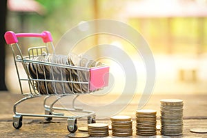 Saving money concept with Money on Cart and Coin stack growing business on sunset background