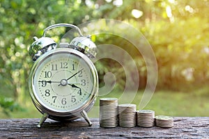 Saving money concept with money coin stack growing and alarm clock for business. financial and accounting concept.
