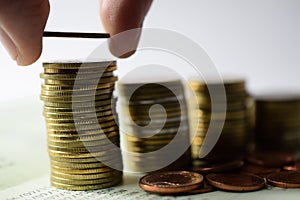 Saving money concept preset by hand putting money coin stack photo