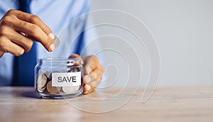 Saving money concept preset by Male hand putting money coin photo