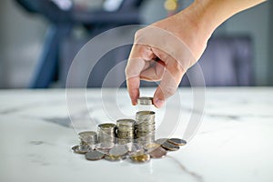 Saving money concept preset by Male hand putting money coin stack growing business photo