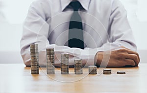 Saving money concept preset, the young man arranged the coins like a graph of the growing business