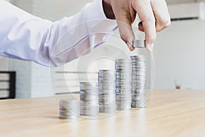 Saving money concept preset, the young man arranged the coins like a graph of the growing business